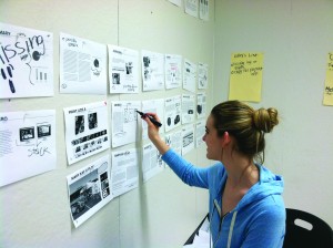 Christy hartman works on the layout of the team's plan book.