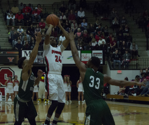 Youngstown State University guard Cameron Morse (24) pulls up for a jumper over two Cleveland State University defenders.