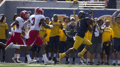 West Virginia University receiver Shelton Gibson (1) makes an over-the-shoulder catch against two Youngstown State University defensive backs.