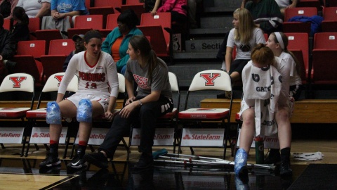 Youngstown State University's Kelsea Newman (far left) and Kelley Wright (right) sit with Nikki Arbanas after leaving the game with injuries.